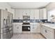 Stylish kitchen featuring stainless steel appliances, gray cabinetry, and modern backsplash at 2520 E 127Th Ave, Thornton, CO 80241