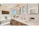 Bright bathroom features skylight, soaking tub, dual sinks, modern mirrors and hardwood floors at 2231 Meadow Green Cir, Franktown, CO 80116