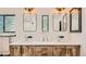 Bathroom featuring dual sinks with wood cabinets and decorative mirrors and hardware at 2231 Meadow Green Cir, Franktown, CO 80116