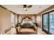 Bedroom with hardwood floors, modern ceiling fan, sliding door access to covered porch and barn door to bath at 2231 Meadow Green Cir, Franktown, CO 80116