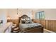 Bedroom featuring wood paneled walls, pendant lights, and a queen-sized bed at 2231 Meadow Green Cir, Franktown, CO 80116