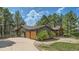 Exterior of home featuring three-car garage, natural landscaping, and a covered porch at 2231 Meadow Green Cir, Franktown, CO 80116