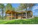 A back view of the house with a wooden deck featuring cable railing and a stone accent wall underneath at 2231 Meadow Green Cir, Franktown, CO 80116
