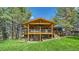 Back of the house showing the covered decks with outdoor living spaces and a well-manicured lawn at 2231 Meadow Green Cir, Franktown, CO 80116