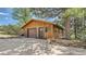 Charming wood-sided garage featuring a brown door, side entry, and ample parking space at 2231 Meadow Green Cir, Franktown, CO 80116
