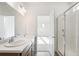Well-lit bathroom featuring double sinks, wood cabinets, and shower with glass door at 13412 E 110Th Way, Commerce City, CO 80022
