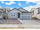 Single-story home with gray siding, stone accents, and attached two-car garage at 13412 E 110Th Way, Commerce City, CO 80022