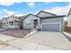 Charming two-story home with gray siding, stone accents, and attached two car garage at 13412 E 110Th Way, Commerce City, CO 80022