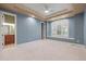 Spacious bedroom with tray ceiling, large window with shutters, and doorway to an en-suite bathroom at 4749 Starfire Cir, Castle Rock, CO 80104