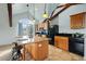 Open kitchen area with island, pendant lighting, stone floors and bright natural light at 4749 Starfire Cir, Castle Rock, CO 80104