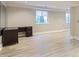 Spacious finished basement with light colored wood flooring and ample natural light from windows at 9705 Autumnwood Pl, Highlands Ranch, CO 80129