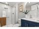 A modern bathroom with a stylish vanity, shower and tub combo, and a round mirror at 4570 E Yale Ave # 507, Denver, CO 80222