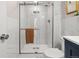 Modern bathroom featuring a glass-enclosed shower with tiled walls and navy blue vanity at 4570 E Yale Ave # 507, Denver, CO 80222