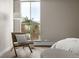 Bright bedroom with large window, chair, and ottoman offering a cozy reading nook near the comfortable sleeping area at 4570 E Yale Ave # 507, Denver, CO 80222