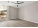 A bright, empty bedroom with laminate flooring, a ceiling fan, and a large window letting in natural light at 4570 E Yale Ave # 507, Denver, CO 80222