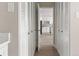 Hallway view of the kitchen through open closet doors with matching white kitchen cabinetry at 4570 E Yale Ave # 507, Denver, CO 80222