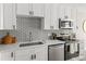 Contemporary kitchen with white cabinets, stainless steel appliances, and a subway tile backsplash at 4570 E Yale Ave # 507, Denver, CO 80222