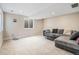 Spacious basement area with neutral carpet, large window, and comfortable sectional couch perfect for entertaining at 9799 Falcon Ln, Littleton, CO 80125
