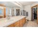 Bathroom showcasing dual sinks, spacious vanity, and walk-in closet at 9799 Falcon Ln, Littleton, CO 80125