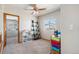 Neutral-toned bedroom with ample space, featuring a window with scenic views and a playful dollhouse at 9799 Falcon Ln, Littleton, CO 80125