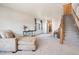 Inviting living room with a comfortable sofa, staircase, and an open view into the adjacent kitchen at 9799 Falcon Ln, Littleton, CO 80125