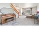 Bright living room with a piano, cozy seating, natural light, and staircase leading to the upper level at 9799 Falcon Ln, Littleton, CO 80125