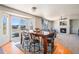 Bright open-concept space with dining area adjacent to a living room with fireplace and expansive windows at 9799 Falcon Ln, Littleton, CO 80125