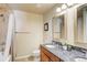 Well-lit bathroom with granite countertop, dual sinks, and a tub-shower combo behind a curtain at 1975 Grant St # 501, Denver, CO 80203
