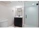 Bathroom featuring a glass shower, black vanity, modern fixtures, and stylish patterned flooring at 2570 Bell Ct, Lakewood, CO 80215