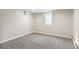 A cozy bedroom with neutral gray carpet, white walls, and baseboards with natural light from the window at 2570 Bell Ct, Lakewood, CO 80215