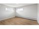 Bright bedroom featuring hardwood floors, two windows for ample natural light, and clean, white walls at 2570 Bell Ct, Lakewood, CO 80215