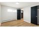 Bedroom with hardwood floors, a window, and dark doors leading to other parts of the house at 2570 Bell Ct, Lakewood, CO 80215