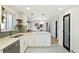 Open kitchen featuring white cabinetry, quartz countertops, designer backsplash, and modern fixtures at 2570 Bell Ct, Lakewood, CO 80215