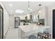 Bright kitchen featuring white cabinets, quartz countertops, stainless steel appliances, and a stylish breakfast bar at 2570 Bell Ct, Lakewood, CO 80215