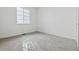 A minimalist bedroom boasts soft carpet, fresh white walls, and a window for ample natural light at 25224 E Warren Pl, Aurora, CO 80018