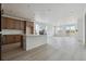Open-concept kitchen features wood cabinets, white countertops, and an island with bar seating overlooking the living area at 25224 E Warren Pl, Aurora, CO 80018