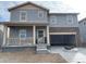 Charming two-story home with a welcoming front porch and stone accents on the garage at 15276 Fillmore St, Thornton, CO 80602