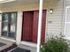 Front door with beige siding and open front door with storm door at 1967 S Oakland Way, Aurora, CO 80014