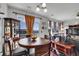 Dining area with a round wooden table, elegant chairs, and decoratively draped windows at 14400 Albrook Dr # 32, Denver, CO 80239