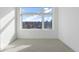 Bright bedroom featuring a large window with scenic neighborhood views and neutral carpeting at 6971 E Lowry Blvd, Denver, CO 80230