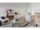 Open-concept living room and kitchen with modern decor and lots of natural light at 6971 E Lowry Blvd, Denver, CO 80230