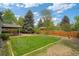 Expansive backyard with patio, lush lawn, mature trees, and privacy fence, perfect for outdoor living at 1590 S Macon St, Aurora, CO 80012