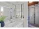 Bright bathroom with white vanity, mirrored medicine cabinet, and glass-enclosed shower at 1590 S Macon St, Aurora, CO 80012