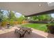 Inviting covered brick patio with picnic table, ideal for outdoor dining and relaxation at 1590 S Macon St, Aurora, CO 80012
