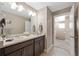 Bathroom showcasing a double vanity with modern fixtures and an entrance to the walk-in closet at 868 N Quatar St, Aurora, CO 80018