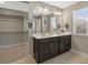 Bathroom featuring a double vanity with dark cabinets, white countertops, and a large mirror at 868 N Quatar St, Aurora, CO 80018