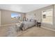 Well-lit bedroom with neutral carpet, a bench at the end of the bed, and a large window at 868 N Quatar St, Aurora, CO 80018