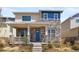Two-story home featuring a stone facade, inviting front porch, and attractive blue door at 868 N Quatar St, Aurora, CO 80018