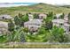 Aerial view of a spacious backyard with a deck, patio, white fence, mature trees, and hillside views at 10529 Dacre Pl, Lone Tree, CO 80124