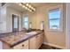 Bathroom features a double vanity with tile countertop, light wood cabinets, and a window offering views at 10529 Dacre Pl, Lone Tree, CO 80124